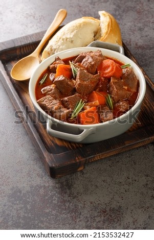 Daube Provencal French stew beef with vegetables is slow simmered to tenderness closeup in the wooden tray on the table. Vertical
