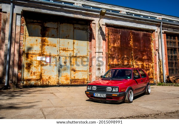 Daugavpils, Latvia - 03.19.2021:
Volkswagen Golf 2 GTI in red color near an old, abandoned garage
