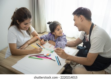 Daughter  asian child to draw picture  paint color in paper table and parent father  mother in room  Include blind curtain  wood floor background  Concept for family  creativity   education 