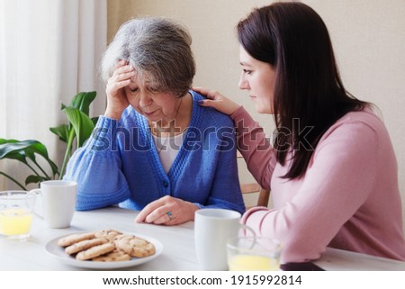 Daughter consoles an elderly mother in illness - A pensioner woman has a bad diagnosis and is worried about her health - A volunteer visits an elderly woman when she is stressed