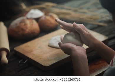 daughter cook dessert bakery at modern kitchen knead dough with hands enjoy preparing cookies bread spend time together. Small girl learn to bake with help of caring mom. - Shutterstock ID 2265260761