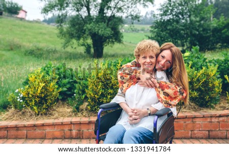 Similar – Young woman talking to elderly woman in wheelchair