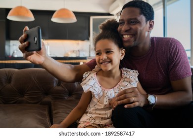 Daughter and father taking a selfie with phone.