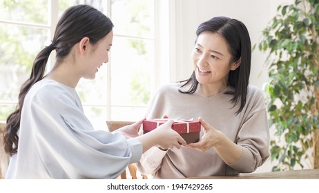 Daughter giving present to mother on Mother's Day