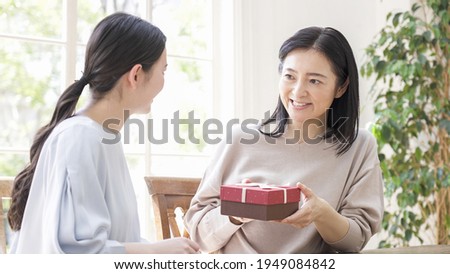 Daughter giving present to mother on Mother's Day