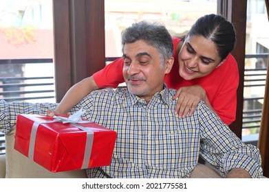 Daughter giving surprise birthday gift to father  - Powered by Shutterstock