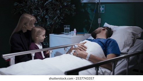 Daughter giving water to dad in hospital bed. - Powered by Shutterstock