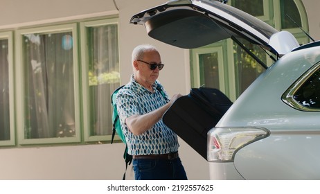 Daughter And Grandparents Loading Voyage Luggage Inside Car Trunk While Going On Summer Field Trip. People Putting Baggage And Trolleys Inside Vehicle While Getting Ready For Citybreak Departure.