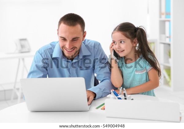 Daughter helping father working in office