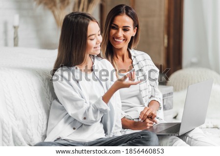 The daughter and her mother spend time together at the computer.