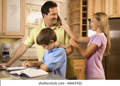 Daughter Holding Cell Phone To Father's Ear While Young Boy Does Homework.