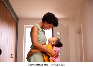 Daughter At Home Hugging Mother As She Helps Her To Get Ready For School
