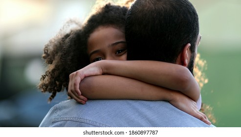 Daughter hugging father outside. Mixed race ethnicity little girl hugs dad. - Shutterstock ID 1860897787