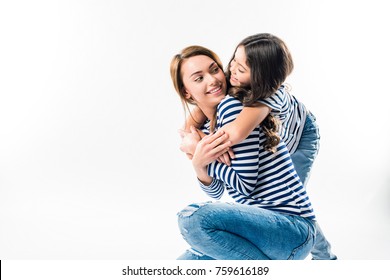 Daughter hugging mother from the back isolated on white