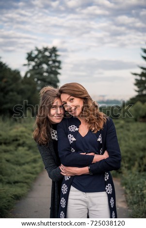 Daughter hugs her mother on the background of the nature