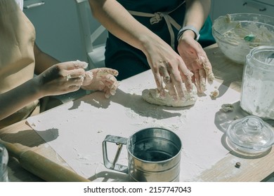 Daughter learning kneading dough with hands helping mom in modern kitchen, happy family adult mother and little child girl prepare cookies