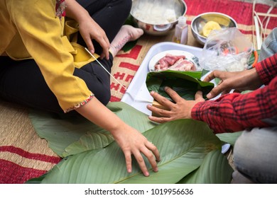 The daughter learning to make Chung cake by hands with his father closeup, Chung cake is the most important traditional Vietnamese lunar New Year (Tet) food.