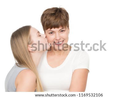 Daughter love. Young blonde female kissing her beautiful happy mother on her cheek isolated copyspace family bonding kiss love affection relationship parent congratulations concept