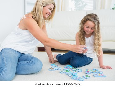Daughter and mother doing a jigsaw puzzle on the floor