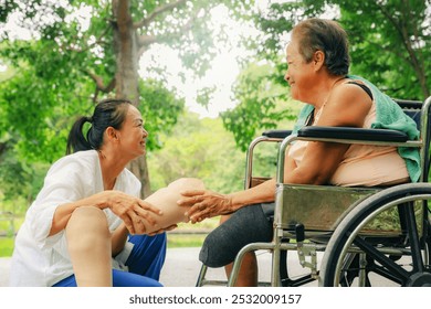 Daughter or nurse caring an elderly disabled woman who has had her legs amputated and is in a wheelchair and is being treated diabetes holds prosthetic leg to be fitted relieve her disability. - Powered by Shutterstock