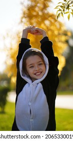 Daughter In A Panda Costume Climbs A Tree