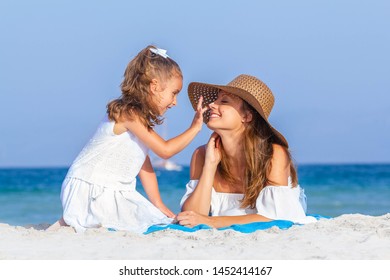 Daughter Putting Sun Lotion On Mothers Face