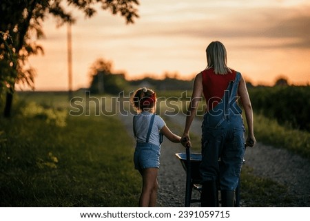 The daughter runs towards her mother in the countryside