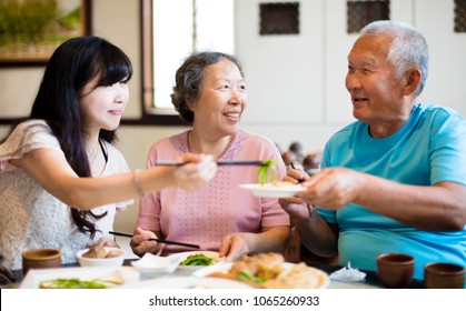 Daughter And Senior Parent Enjoy Dinner In Restaurant
