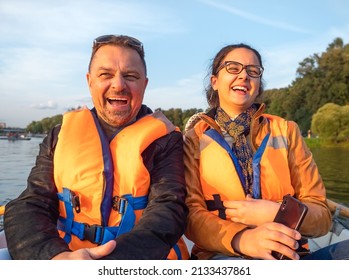 daughter teenager on boat with dad in life jackets in summer on lake. Family having fun laughing - Powered by Shutterstock