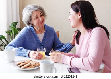 A Daughter Visits An Elderly Mother And They Talk Together At Breakfast - A Retiree Woman Is Visited By A Volunteer And Talks To Maintain Mental Health - Concept Of The Connection Between Generations