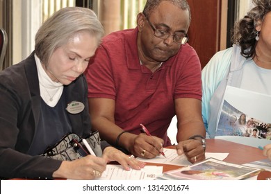 Davie, Florida / USA - January 30 2019: Broward County Census 2020 Kickoff Meeting At Tree Tops Park Man And Woman Filling Out Document Forms With Pen And Pencil At A Table During A Meeting.