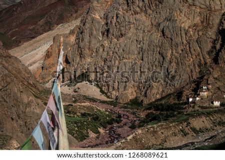 Dawn breaks as the full moon sets over Mudh village in Pin River Valley, Himachal Pradesh / India: A cold desolate desert mountain valley located very high in the rain shadow region of the himalayas.