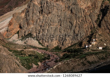 Dawn breaks as the full moon sets over Mudh village in Pin River Valley, Himachal Pradesh / India: A cold desolate desert mountain valley located very high in the rain shadow region of the himalayas.