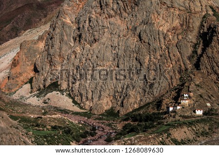 Dawn breaks as the full moon sets over Mudh village in Pin River Valley, Himachal Pradesh / India: A cold desolate desert mountain valley located very high in the rain shadow region of the himalayas.