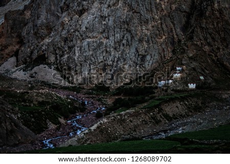 Dawn breaks as the full moon sets over Mudh village in Pin River Valley, Himachal Pradesh / India: A cold desolate desert mountain valley located very high in the rain shadow region of the himalayas.