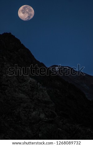 Dawn breaks as the full moon sets over Mudh village in Pin River Valley, Himachal Pradesh / India: A cold desolate desert mountain valley located very high in the rain shadow region of the himalayas.