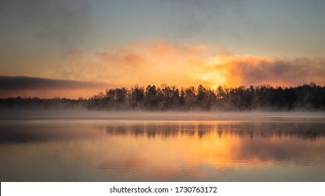 Dawn landscape at Lake Ontelaunee over a forested shore with fog at the water's surface - Powered by Shutterstock