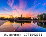 Dawn over Victory Park on Poklonnaya Hill in Moscow in the summer. Colorful blue sky with clouds and sunrise on the horizon above an Orthodox church. The sky is reflected in the pool of the fountain.