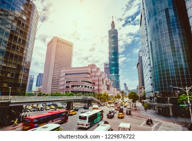Dawn view of a pedestrian footbridge over a busy street corner in Taipei City with Taipei 101 Tower and World Trade Center in Xinyi District ~ Beautiful scenery of Taipei Downtown at rush hour