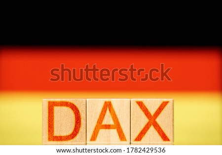 dax index concept. wooden blocks with the word dax on the background of the national flag of germany