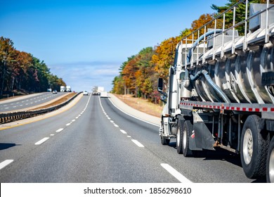 Day Cab White Big Rig Semi Truck Transporting Dangerous Cargo In Red Armored Tank Semi Trailer For For The Transportation Of Chemical And Flammable Substances Running On The Road In New England