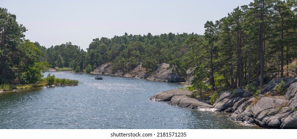 A Day Cruiser Leaving An Inlet Bay, Cliffs With Pine Trees And Smooth Cliffs A Sunny Summer Day In Stockholm, Sweden 2022-07-20
