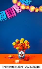 Day Of The Dead Dia De Los Muertos Celebration Background With Marigolds Or Cempasuchil Flowers In Vase And Papel Picado Decor. Bright Orange And Blue Copy Space Traditional Mexican Culture Festival