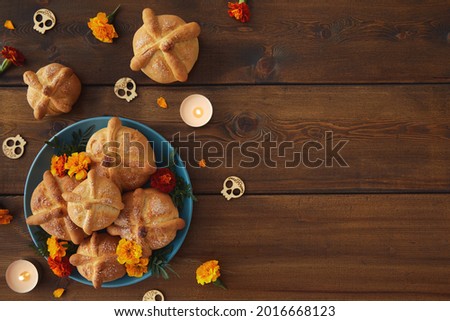 Day of the dead, Dia De Los Muertos celebration party Background With bread of death or Pan de Muerto, Skulls, marigolds flowers on dark wood table with Copy Space. Traditional Mexican culture 