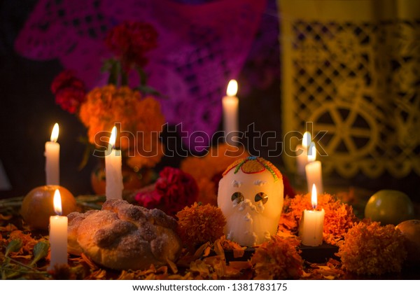 Day of the dead Sugar\
skull with candles, bread and flowers altar decoration at Janitzio,\
Michoacan