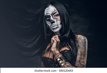 Day of the dead. Tattooed female with sugar skull make up.