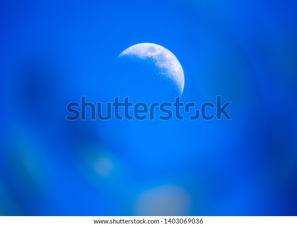 Day moon in the blue sky creating a good\
astronomy background.