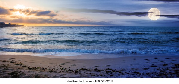 Day And Night Time Change Concept At The Seaside In Summer. Beautiful Seascape With Sun And Moon. Calm Waves Wash The Golden Sandy Beach. Fluffy Clouds On The Sky