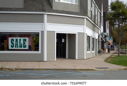 Day Time Exterior Generic No Signage Retail Clothing Storefront On A Main Street In Small Town Anywhere USA. People Window Shop Up And Down Sidewalk