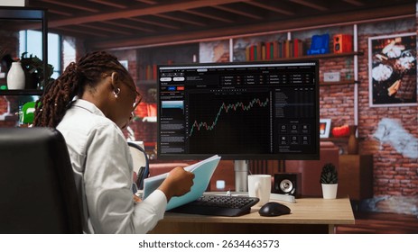 Day trader using PC to purchase and sell stocks, browsing through documentation files to learn how to maximize profits. Investor looking at stock exchange graphs on computer monitor, camera A
